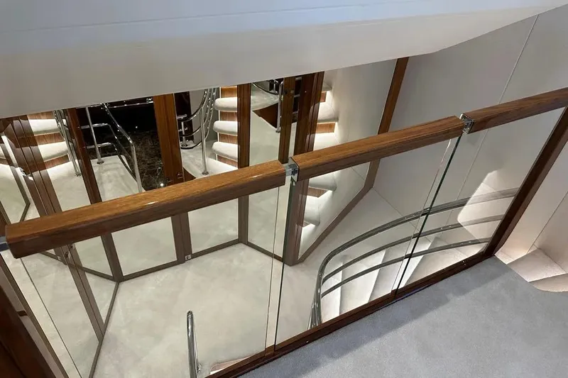  Yacht Photos Pics Luxurious interior of 2018 Sunseeker 95 yacht with elegant staircase and glass railings.