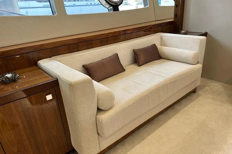  Yacht Photos Pics Luxurious interior of 2018 Sunseeker 95 yacht with elegant beige sofa and wooden accents.