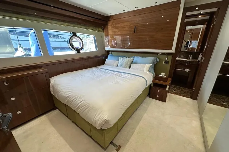  Yacht Photos Pics Luxurious bedroom interior of 2018 Sunseeker 95 yacht with elegant wood finishes.