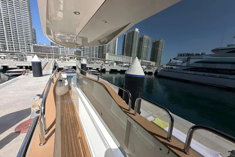  Yacht Photos Pics Luxurious 2018 Sunseeker 95 yacht docked at a modern marina with skyscrapers.