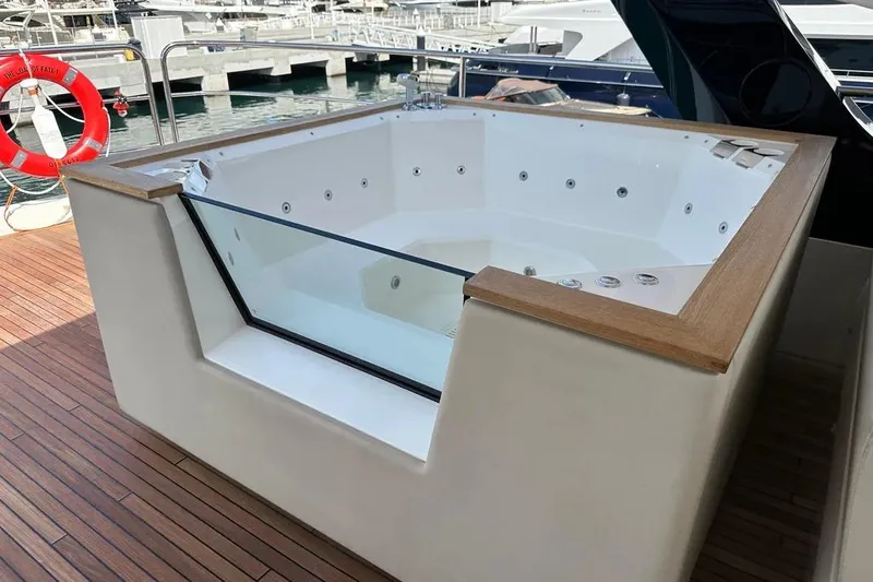  Yacht Photos Pics Luxurious jacuzzi on 2018 Sunseeker 95 yacht, featuring wooden trim and glass panel.