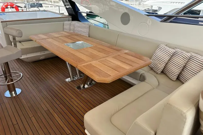  Yacht Photos Pics Luxurious Sunseeker 95 yacht interior with wooden table and cushioned seating, 2018 model.