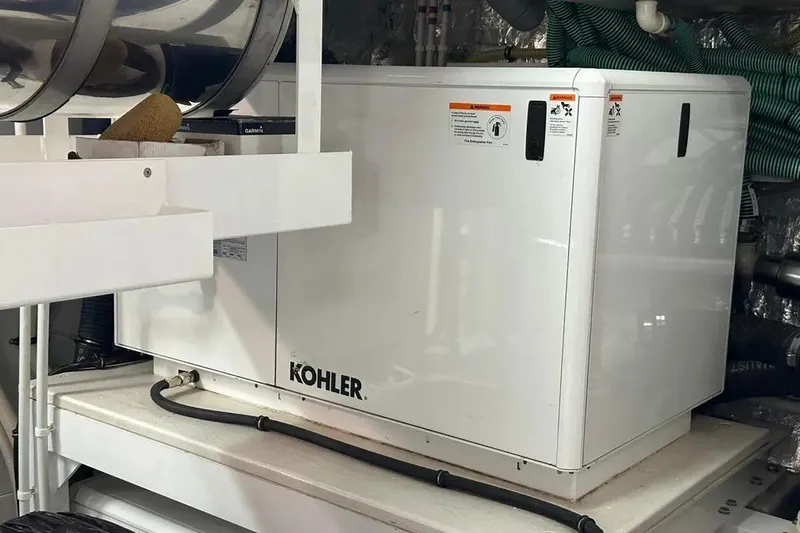 Yacht Photos Pics Kohler generator in 2018 Sunseeker 95 yacht engine room, surrounded by equipment and hoses.