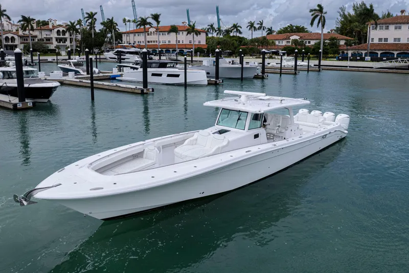 Our Trade Yacht Photos Pics 2024 HCB 53 Sueños luxury boat docked in a marina with palm trees.
