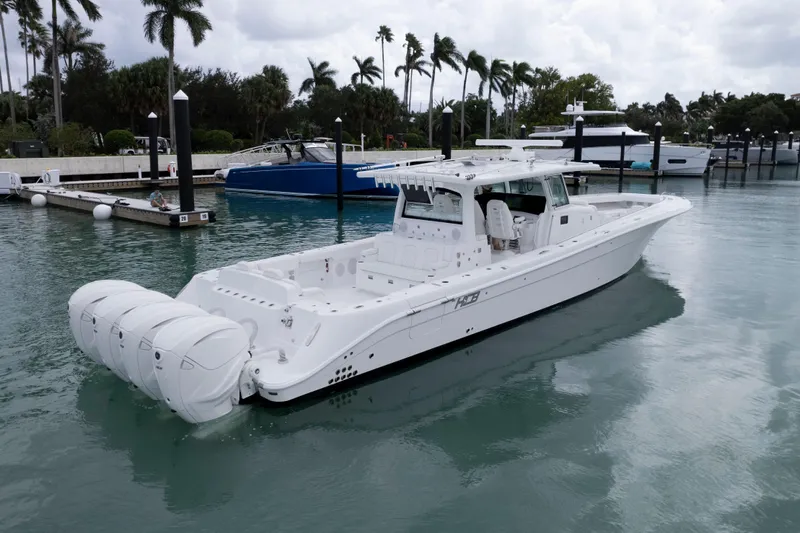 Our Trade Yacht Photos Pics 2024 HCB 53 Sueños luxury boat docked in a marina with palm trees.