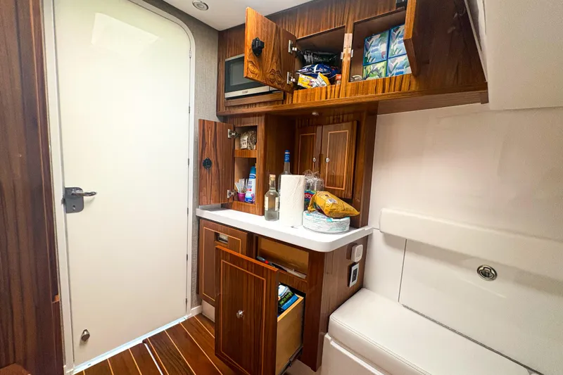 Our Trade Yacht Photos Pics 2024 HCB 53 Sueños yacht interior with wooden cabinets and kitchenette essentials.