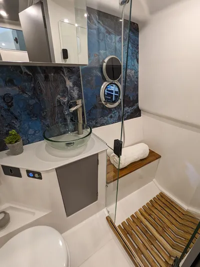 Custom Order Your 347 Today! Yacht Photos Pics Modern bathroom in 2025 Hanover 347 Inboard boat with glass sink and wooden accents.