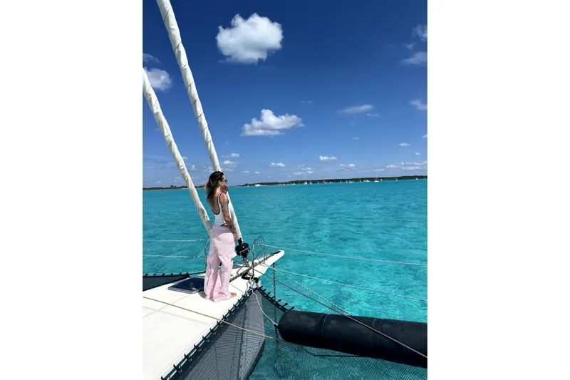 Who Cares Yacht Photos Pics Person enjoying a sunny day on a NEEL 51 trimaran, 2020, in clear turquoise waters.