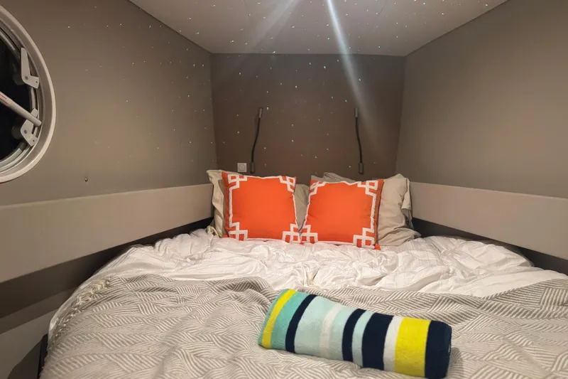 Who Cares Yacht Photos Pics Cozy cabin bedroom in 2020 NEEL 51 trimaran with orange pillows and striped towel.