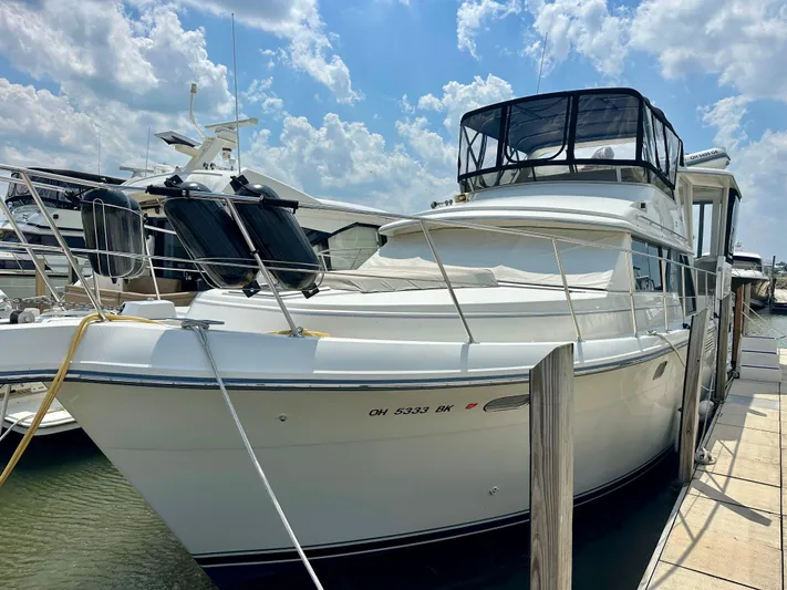 Dawn Yacht Photos Pics 1995 Carver 440 Aft Cabin Motor Yacht docked under a partly cloudy sky.