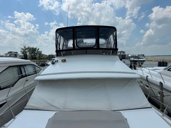 Dawn Yacht Photos Pics 1995 Carver 440 Aft Cabin Motor Yacht docked under a partly cloudy sky.