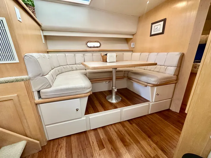 Dawn Yacht Photos Pics 1995 Carver 440 Aft Cabin Motor Yacht interior with cozy dining area and wooden flooring.