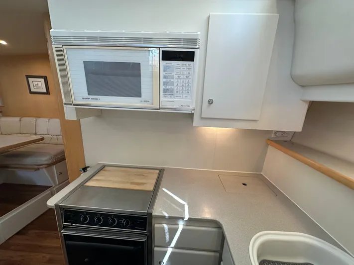 Dawn Yacht Photos Pics 1995 Carver 440 Aft Cabin Motor Yacht kitchen with microwave, stove, and dining area.