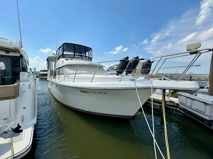 Dawn Yacht Photos Pics 1995 Carver 440 Aft Cabin Motor Yacht docked at marina under blue sky.
