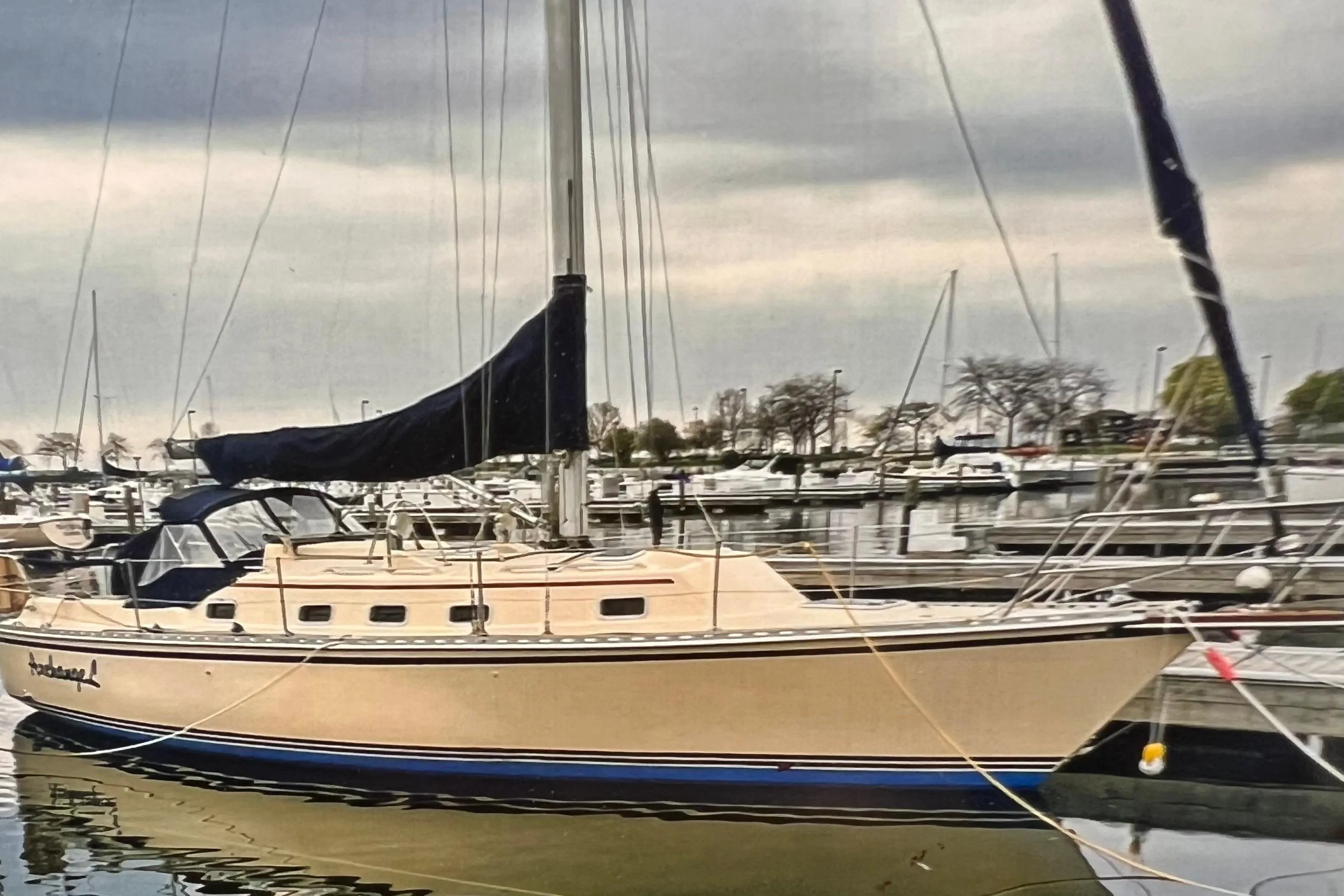 1996 Caliber 35 LRC sailboat docked in a marina under cloudy skies.