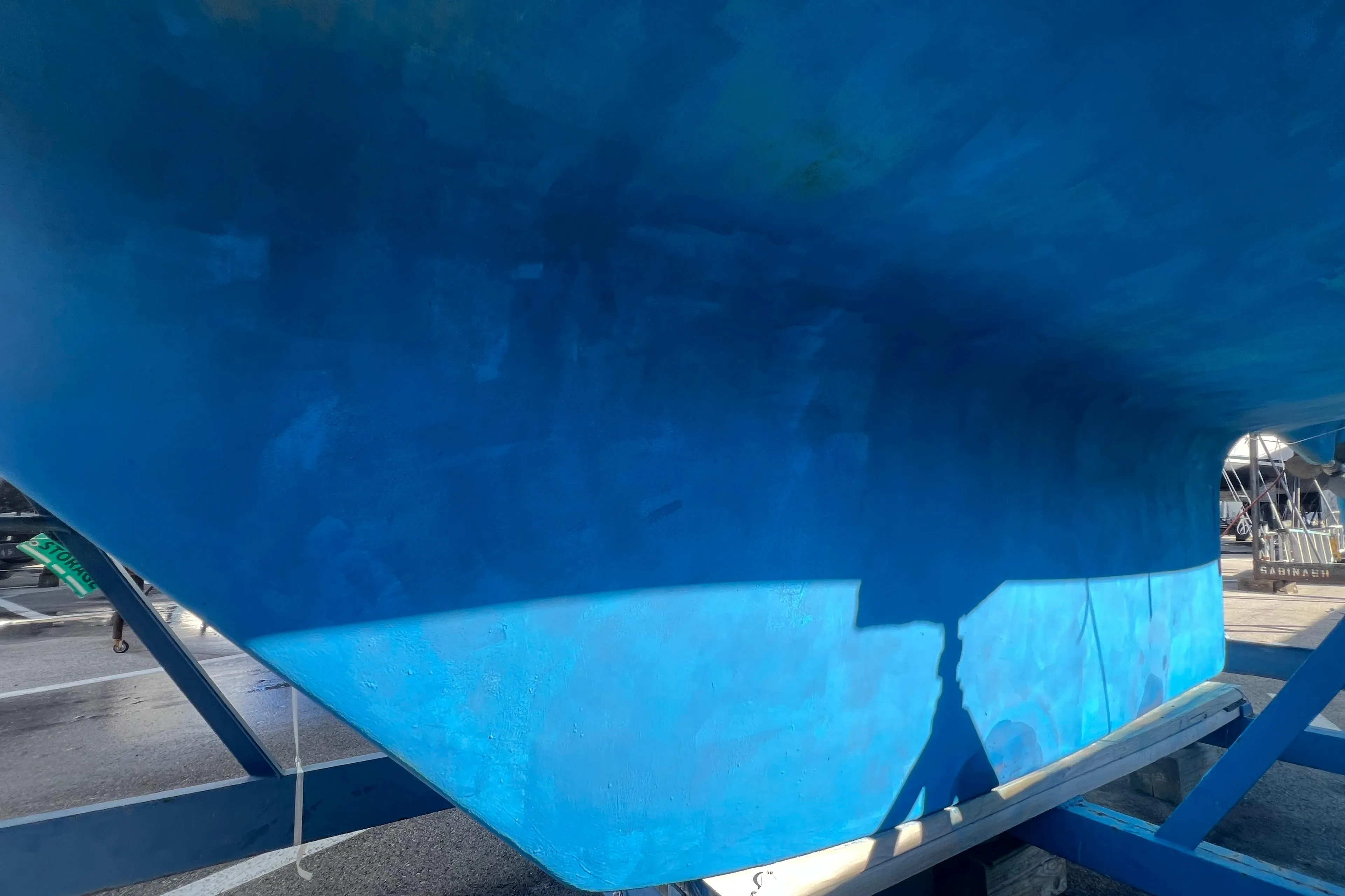Blue hull of a 1996 Caliber 35 LRC sailboat on a trailer.