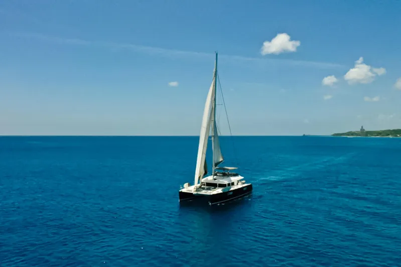 Cool Runnings IV Yacht Photos Pics Sailing Lagoon 560 S2 catamaran on open sea under clear blue sky.