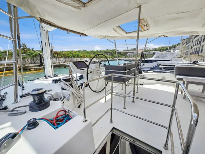 Cool Runnings IV Yacht Photos Pics 2015 Lagoon 560 S2 yacht cockpit with steering wheel and marina view.