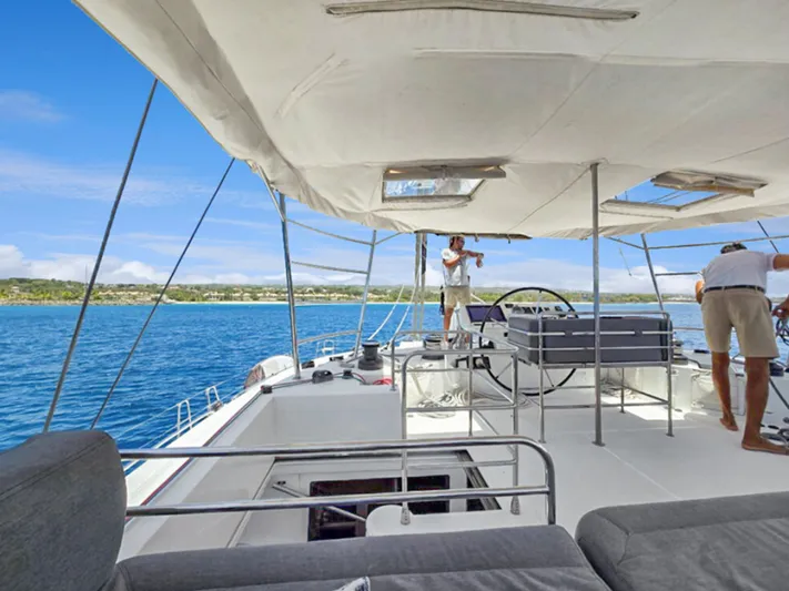 Cool Runnings IV Yacht Photos Pics 2015 Lagoon 560 S2 yacht deck with people sailing on blue ocean.
