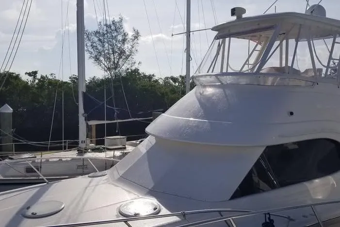 Plane Pirate Yacht Photos Pics 2004 Riviera 37 Convertible yacht docked, featuring sleek design and spacious flybridge.