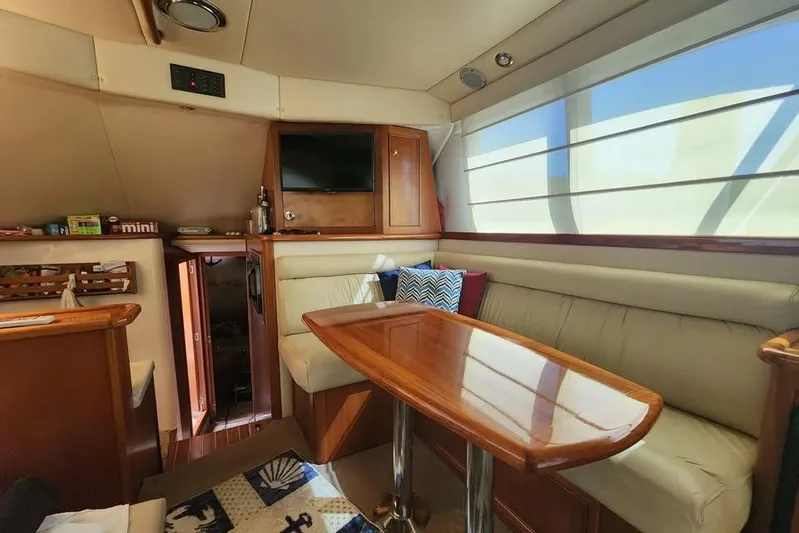 Plane Pirate Yacht Photos Pics Luxurious interior of a 2004 Riviera 37 Convertible yacht with plush seating and wooden table.