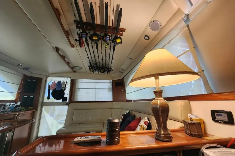 Plane Pirate Yacht Photos Pics Interior of 2004 Riviera 37 Convertible yacht with fishing rods and cozy seating area.