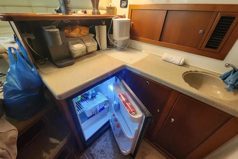 Plane Pirate Yacht Photos Pics 2004 Riviera 37 Convertible yacht kitchen with open fridge and countertop essentials.