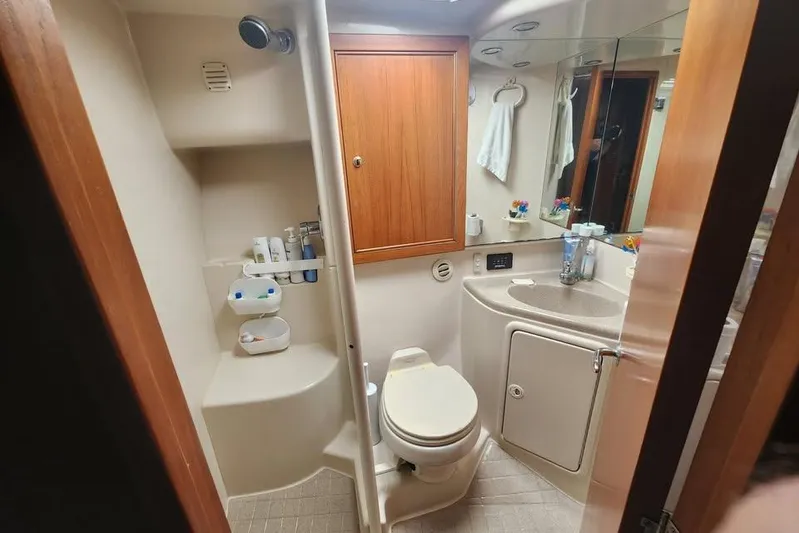 Plane Pirate Yacht Photos Pics 2004 Riviera 37 Convertible yacht bathroom with shower, sink, and storage.