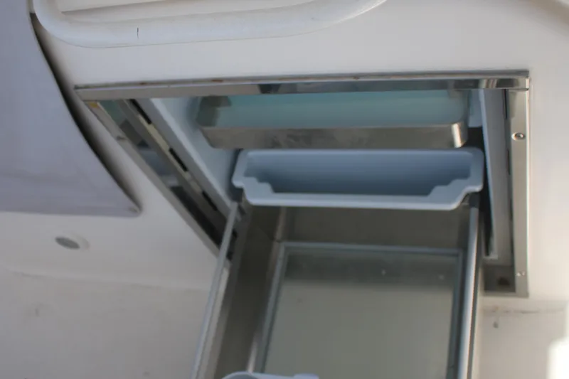 Plane Pirate Yacht Photos Pics Open storage compartment on 2004 Riviera 37 Convertible boat, featuring a sliding drawer.