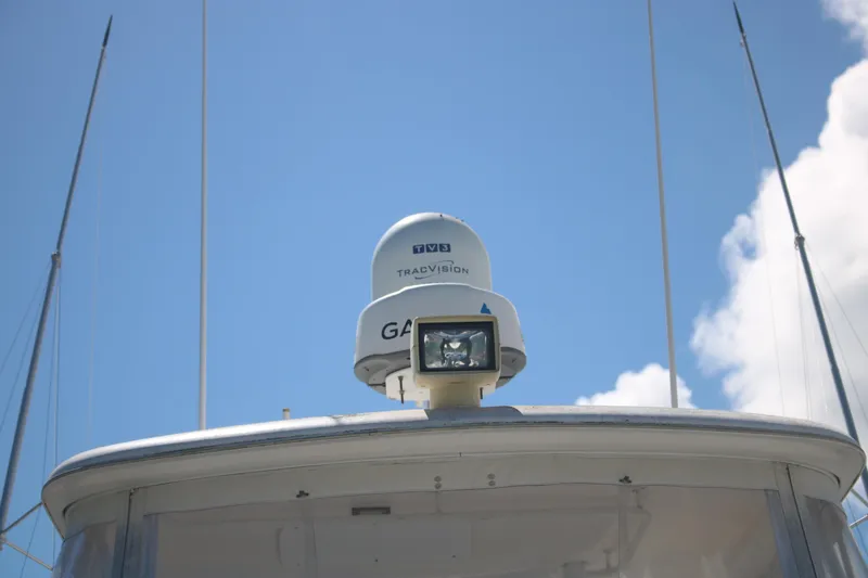 Plane Pirate Yacht Photos Pics 2004 Riviera 37 Convertible boat with TracVision satellite dome under blue sky.