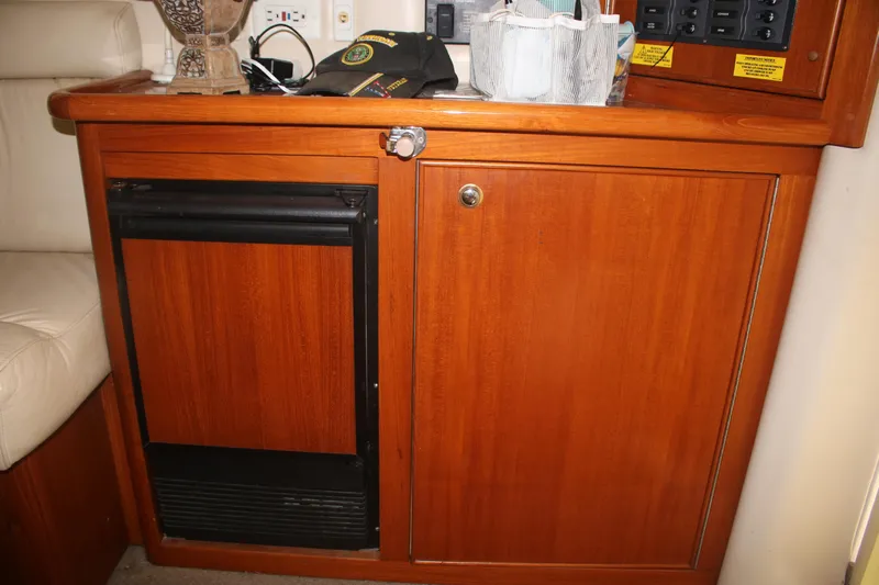 Plane Pirate Yacht Photos Pics 2004 Riviera 37 Convertible interior with wooden cabinetry and mini fridge.