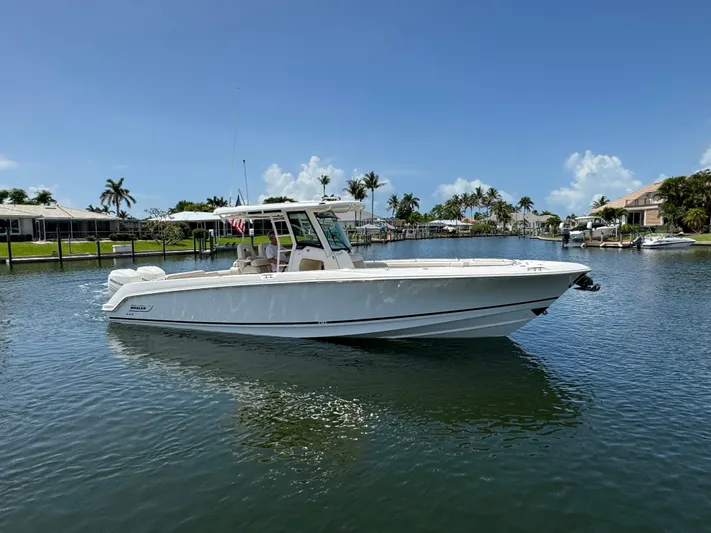  Yacht Photos Pics 2018 Boston Whaler 330 Outrage boat on a sunny day in a calm marina.
