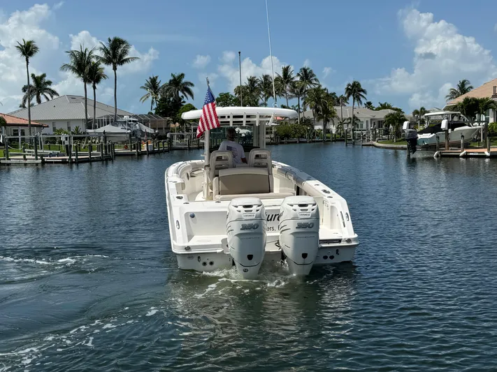  Yacht Photos Pics 2018 Boston Whaler 330 Outrage cruising in a scenic canal with palm trees.