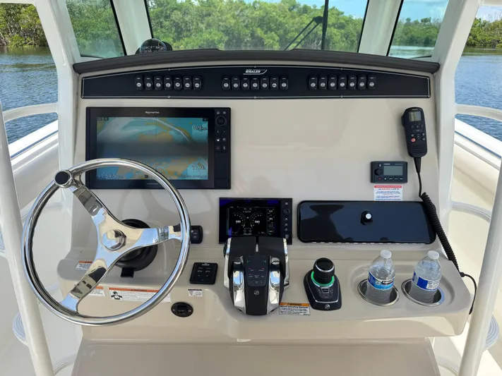  Yacht Photos Pics Control panel of 2018 Boston Whaler 330 Outrage with steering wheel and navigation equipment.