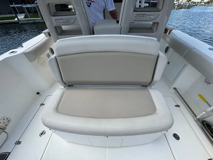  Yacht Photos Pics 2018 Boston Whaler 330 Outrage boat seating area with cushioned bench and storage.