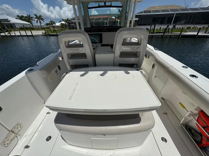  Yacht Photos Pics 2018 Boston Whaler 330 Outrage boat interior with seating and table, docked by waterfront homes.