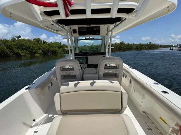  Yacht Photos Pics 2018 Boston Whaler 330 Outrage boat interior with seating, on a calm waterway.
