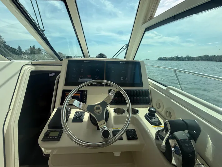  Yacht Photos Pics 2018 Boston Whaler 345 Conquest helm with steering wheel and navigation controls.