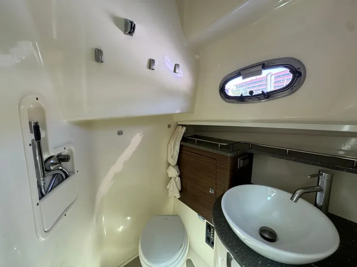  Yacht Photos Pics 2018 Boston Whaler 345 Conquest bathroom with sink, toilet, and porthole window.