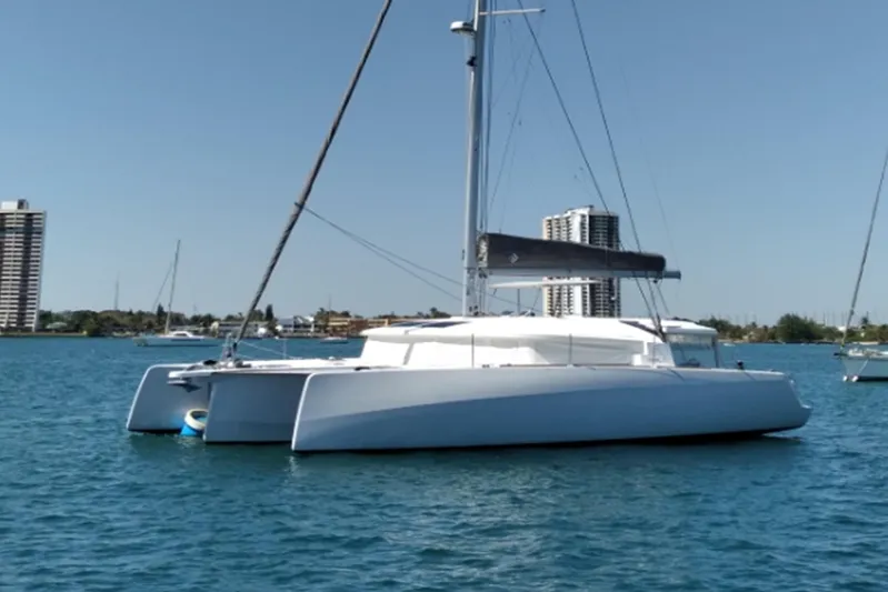  Yacht Photos Pics 2023 NEEL 43 trimaran sailing on calm waters near city skyline.