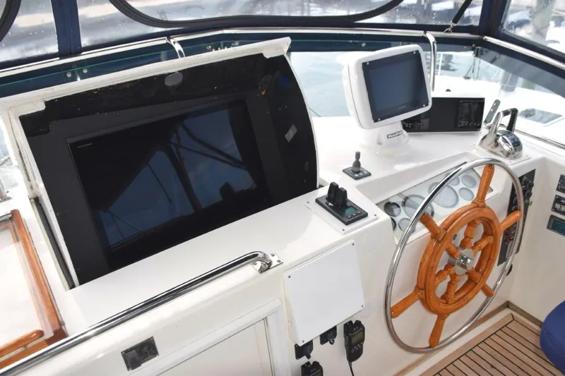 Jamie Lyn Yacht Photos Pics 1997 Grand Banks Classic helm with wooden wheel and modern navigation equipment.