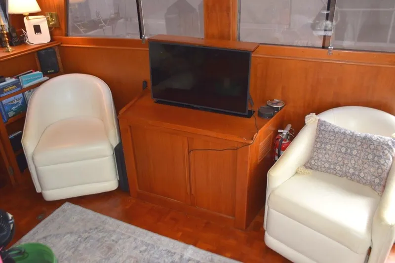 Jamie Lyn Yacht Photos Pics Interior of 1997 Grand Banks Classic yacht with chairs, TV, and wooden cabinetry.