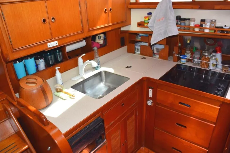 Jamie Lyn Yacht Photos Pics 1997 Grand Banks Classic yacht kitchen with wooden cabinetry, sink, and stove.