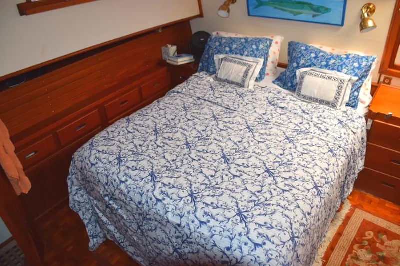 Jamie Lyn Yacht Photos Pics Cozy bedroom in 1997 Grand Banks Classic yacht with nautical decor and wooden cabinetry.