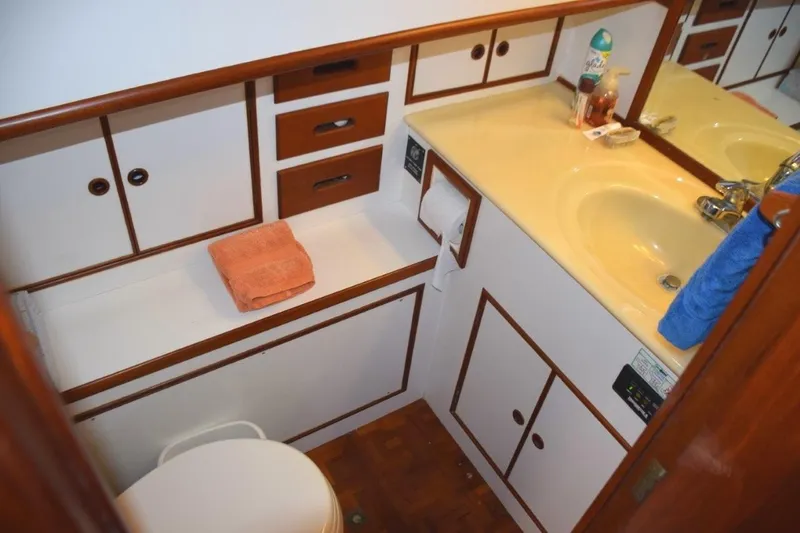 Jamie Lyn Yacht Photos Pics Bathroom interior of 1997 Grand Banks Classic yacht with wooden cabinetry and yellow sink.