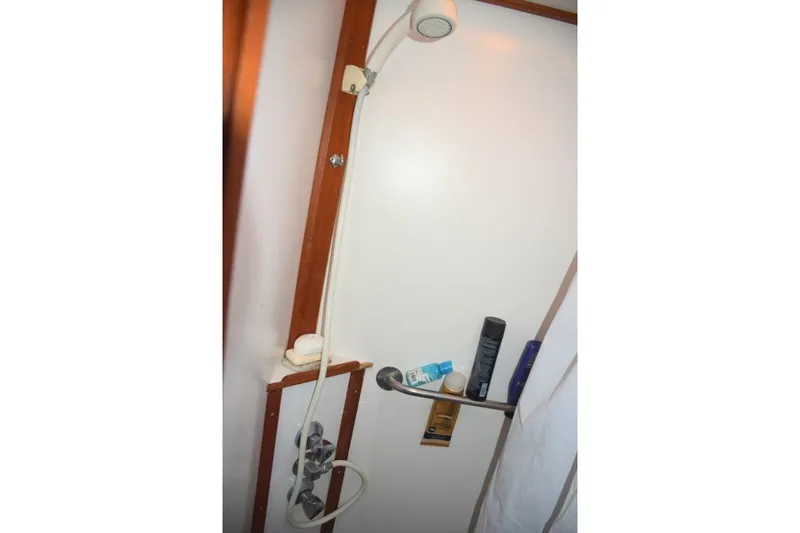 Jamie Lyn Yacht Photos Pics Shower area in a 1997 Grand Banks Classic boat with toiletries and wooden accents.