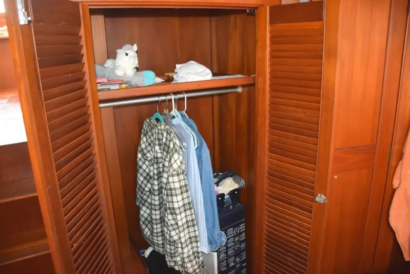 Jamie Lyn Yacht Photos Pics Wooden closet interior on a 1997 Grand Banks Classic boat, with hanging clothes and shelves.