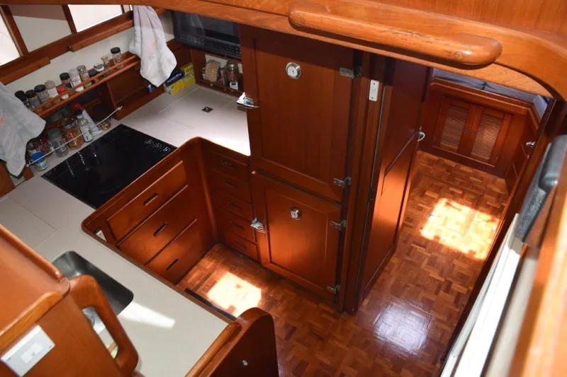 Jamie Lyn Yacht Photos Pics Interior of 1997 Grand Banks Classic yacht kitchen with wooden cabinetry and parquet flooring.