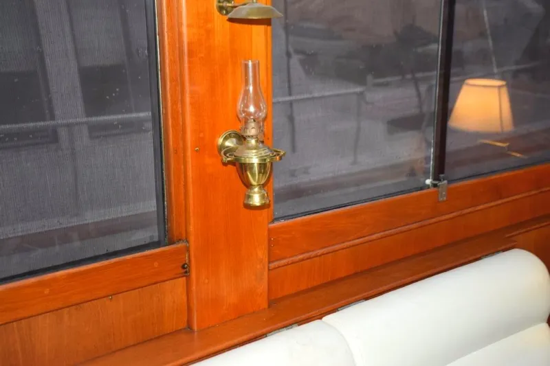 Jamie Lyn Yacht Photos Pics Interior of 1997 Grand Banks Classic yacht with brass oil lamp and wooden paneling.