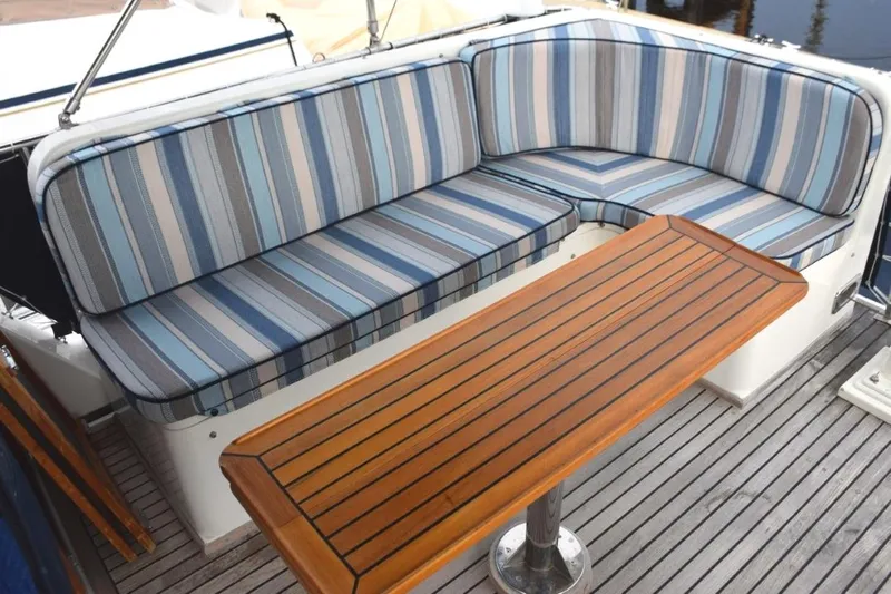 Jamie Lyn Yacht Photos Pics Striped seating and wooden table on 1997 Grand Banks Classic yacht deck.